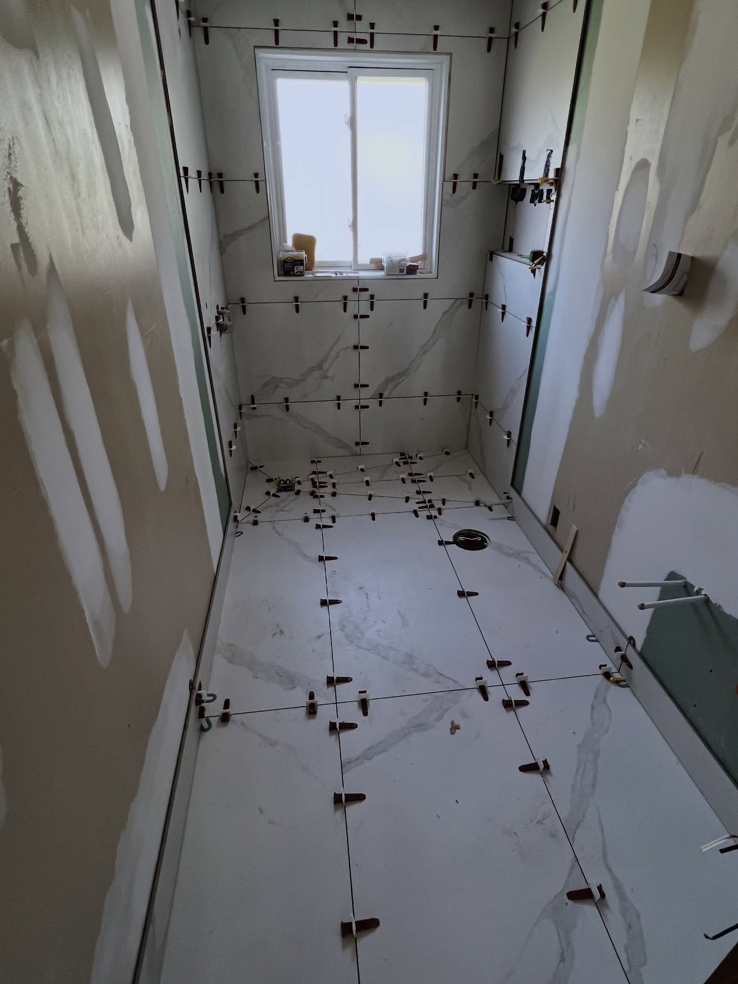 Bathroom renovation detail showing custom tile installation and modern vanity - Professional renovation services